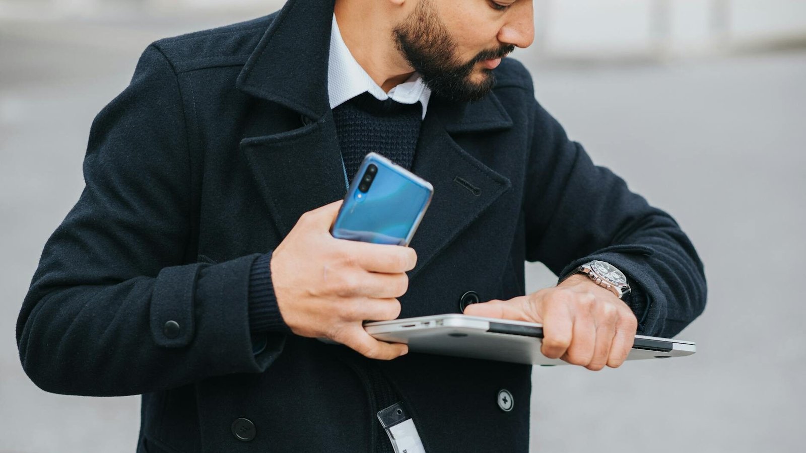 crop ethnic manager with multimedia devices watching time on wristwatch